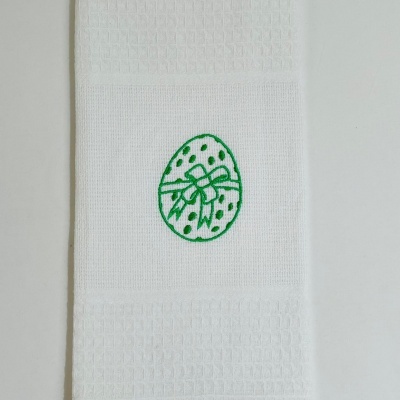 Toalha branca com bordado verde de ovo com laço e pontos