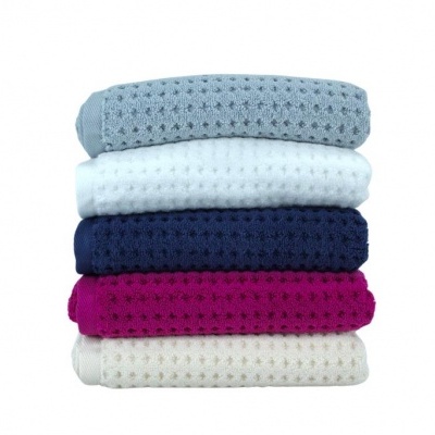 Pilha de cinco toalhas coloridas com padrão quadriculado sobre fundo branco