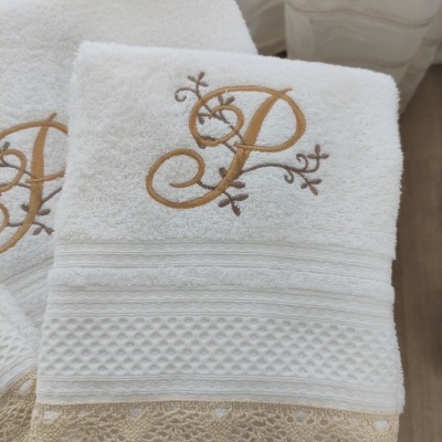 Toalhas brancas com bordado 'P' dourado e renda bege