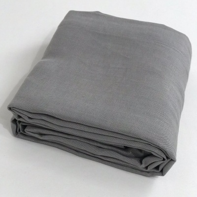 Manta cinzenta dobrada sobre superfície branca