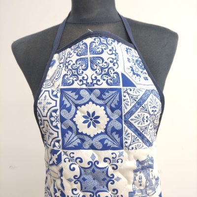 Avental azul e branco com padrão de azulejos no manequim preto