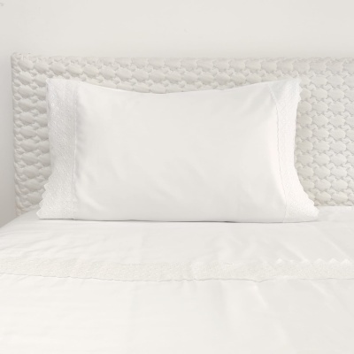 Almofada branca com bordado em cama com cabeceira acolchoada branca