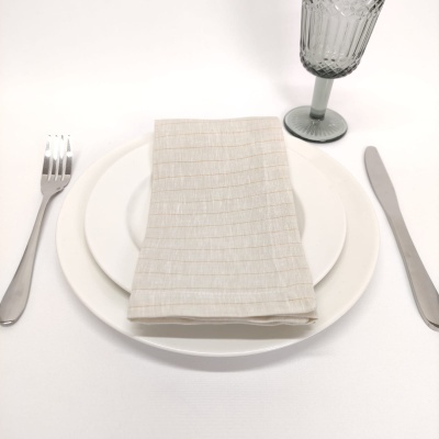 Conjunto de pratos brancos, guardanapo bege, talheres prateados e copo cinza texturizado sobre superfície branca