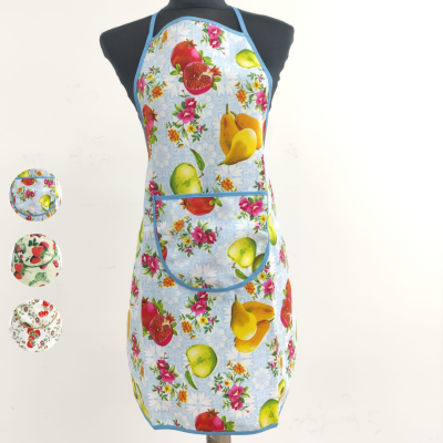 Avental de cozinha com padrão colorido de frutas e flores em fundo azul claro e bolso frontal.