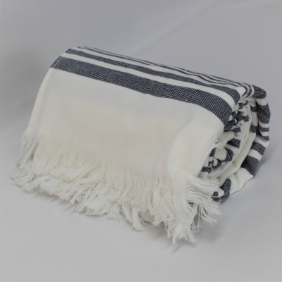 Toalha branca com riscas azuis e franjas, dobrada