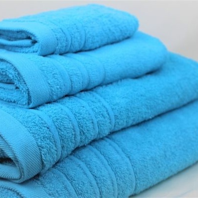 Conjunto de toalhas azuis empilhadas sobre fundo branco