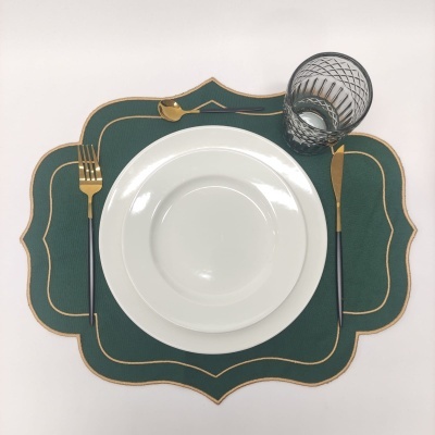 Conjunto de jantar branco com talheres dourados e base verde