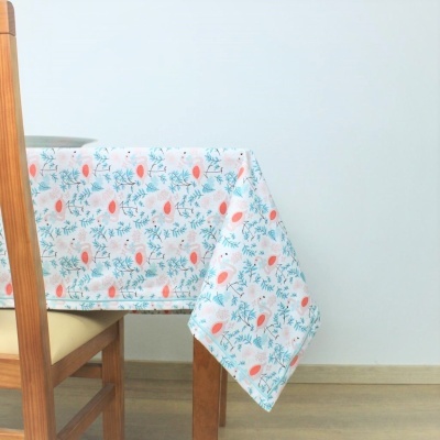 Toalha de mesa floral em mesa de madeira com cadeira estofada