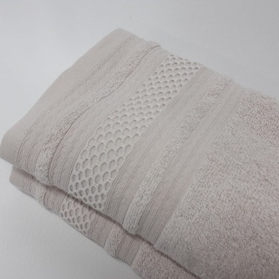 Toalha de banho bege clara texturizada dobrada