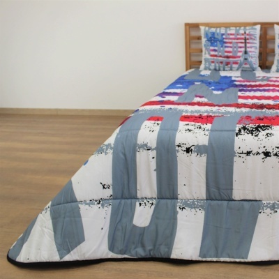 Colcha colorida em cima de cama com riscas largas e cabeceira de madeira