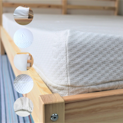 Colchão branco estrado numa cama de madeira clara com textura pontilhada e selo em relevo