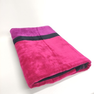 Toalha rosa forte com faixa preta dobrada sobre fundo branco