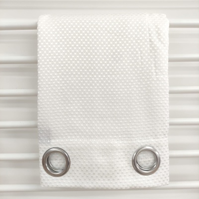 Pano de cozinha branco com padrão texturizado e ilhós metálicos