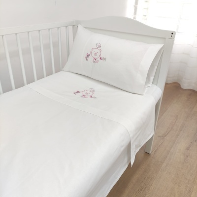 conjunto de cama branco com bordado de ursinho e flores em berço branco
