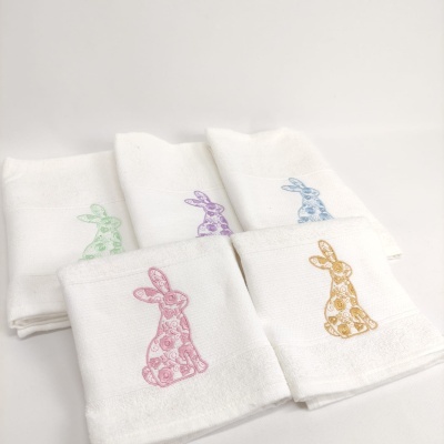 Toalhas brancas com bordados coloridos de coelhos em tecido texturado
