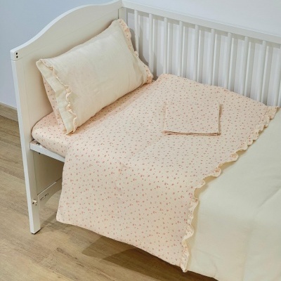 Cama de criança com roupa de cama creme e bege com padrão floral