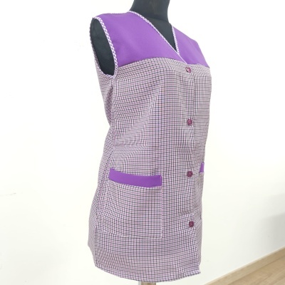 Vestido de trabalho lilás com padrão xadrez e bolsos numa sala com fundo branco.