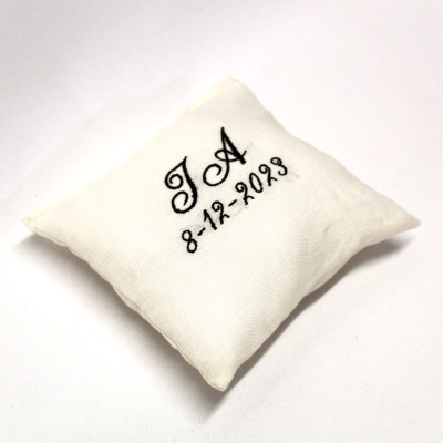 almofada branca bordada com letras e data
