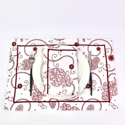 Conjunto de jogo americano e guardanapo em tecido branco com padrão vermelho com prato e talheres