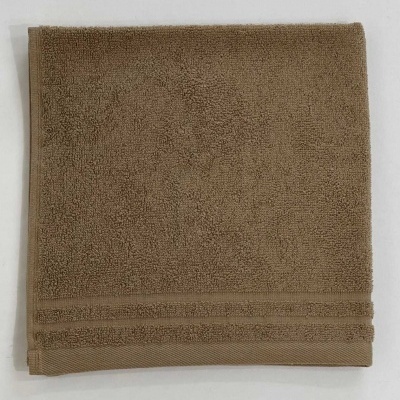 Toalha castanha clara com textura felpuda e linhas decorativas