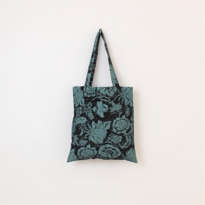 Saco de tecido azul e preto com padrão floral pendurado na parede