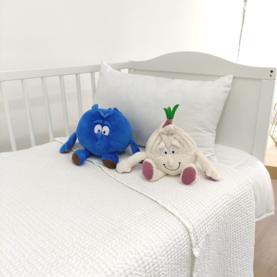 Cama de bebé branca com peluches azul e creme e roupa de cama branca