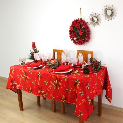 Mesa de madeira com toalha de mesa natalícia vermelha e decoração festiva