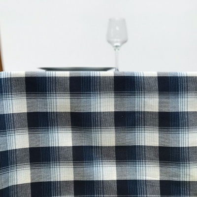 toalha de mesa xadrez azul em mesa de madeira com copo de vidro