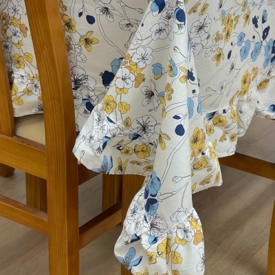 Toalha de mesa floral azul e amarelo sobre mesa de madeira