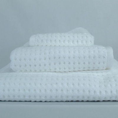 Três toalhas brancas com textura bolha empilhadas