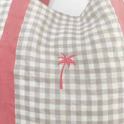 Bolsa de tecido xadrez bege e branco com bordado de palmeira rosa
