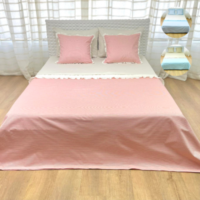 Conjunto de cama rosa e branca com duas almofadas cor-de-rosa em quarto iluminado