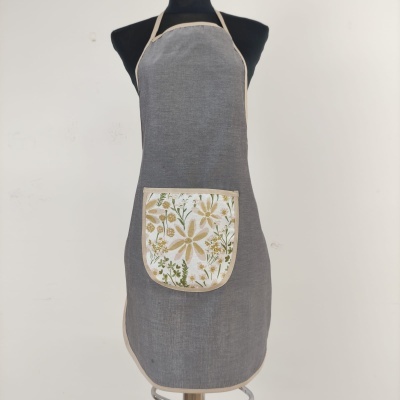 Avental cinzento com bolso floral num manequim