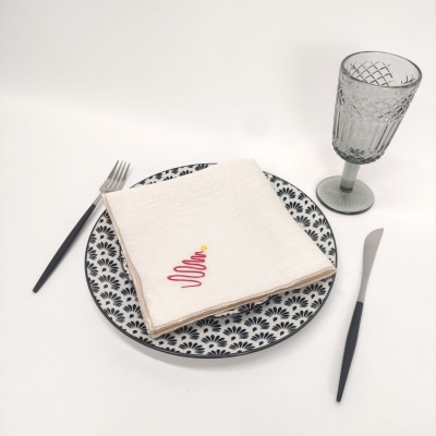 Conjunto de jantar com prato cerâmico, guardanapo branco bordado, talheres e vidro texturizado