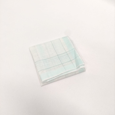 Pano de cozinha dobrado com padrão de riscas azul e verde