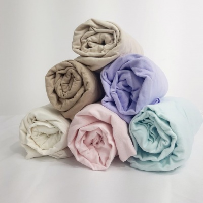 Lençóis enrolados em várias cores sobre fundo branco