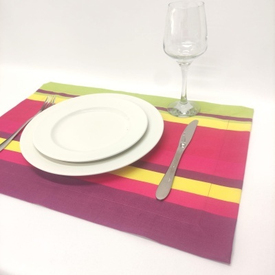 Conjunto de serviço de mesa com guardanapo colorido, pratos brancos, garfo, faca e taça