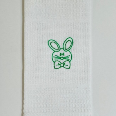 Toalha branca com bordado de coelho verde e textura quadriculada