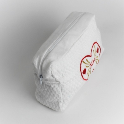 Estojo branco acolchoado com bordado de coração e fecho de correr