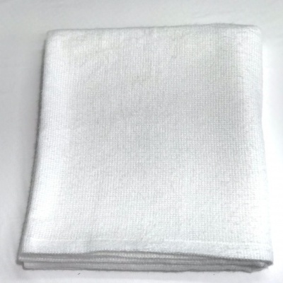 Toalha branca dobrada sobre superfície branca