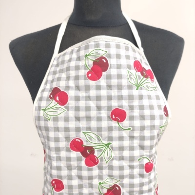 Avental com padrão de quadrados cinza e branco e cerejas vermelhas em manequim preto
