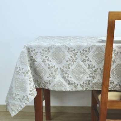 Toalha de mesa bege e branca com padrão floral em mesa de madeira e cadeira