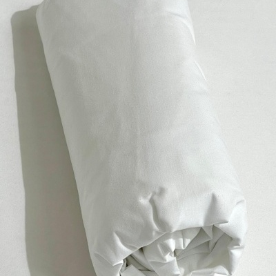 Colchão branco enrolado sobre superfície branca