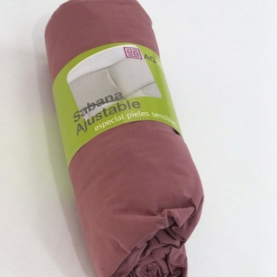Sábana ajustable rosa con etiqueta verde