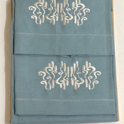 Toalhas azul claro com bordados brancos e costura nas bordas