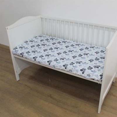 Berço branco de madeira com colchão floral azul