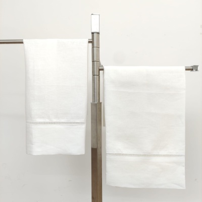 Duas toalhas de banho brancas em suporte metálico prateado