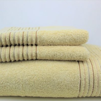 Conjunto de três toalhas amarelas empilhadas com linhas decorativas.