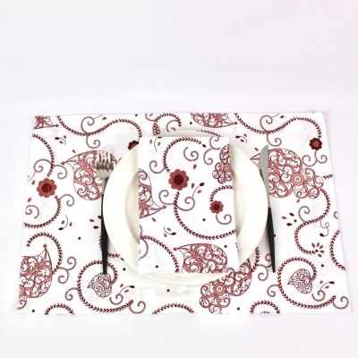 Jogo americano e guardanapo branco com padrão floral castanho e vermelho, prato branco
