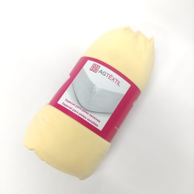 Rolo de tecido amarelo claro com etiqueta AGTÊXTIL cor-de-rosa